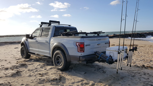 Custom made surf fishing rod holder for truck and cargo bed partition with  tie-down rings.